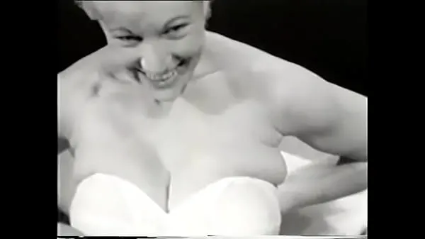 XXX Sexy blonde in a white corset poses for the camera exposing her big tits to a photographer from the 60s for a men's magazine top Videos
